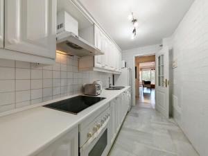 a white kitchen with white cabinets and a sink at Sea View - Pool view - Beach Front - 25 meter to beach in Málaga