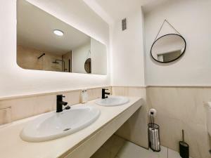 a bathroom with two sinks and a mirror at Sea View - Pool view - Beach Front - 25 meter to beach in Málaga