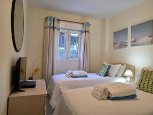 a hotel room with two beds and a television at Sea View - Pool view - Beach Front - 25 meter to beach in Málaga +8 photos