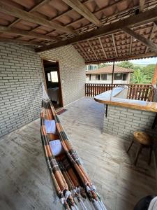 a hammock sitting on a patio with a table at Chalé samambaia in Resende