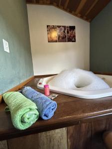 a bathroom with towels sitting on a wooden counter at Chalé samambaia in Resende