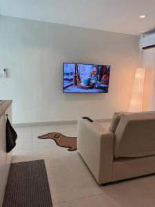 a living room with a couch and a tv on the wall at 2 Bed & 2 Bath Suite, 4th floor in Ban Bang Toei (1)