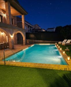 a large swimming pool in a yard at night at MEQUEDO el ESPOLON in Alcañiz