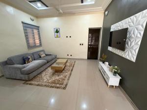 a living room with a couch and a tv at Jfk3 in Ouagadougou +6 photos