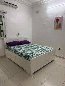 a bed in a white room with a mattressvisor at Jfk3 in Ouagadougou