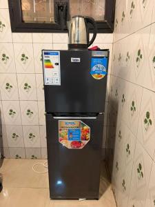 a refrigerator with a tea kettle on top of it at Jfk3 in Ouagadougou