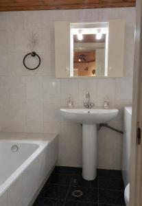 a bathroom with a sink and a bath tub at Τα σπίτια στα Λειβάδια - Γαρδένια in Vrakhnós