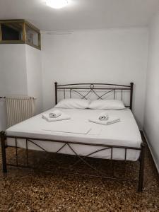 a bed with a metal frame and white sheets at Τα σπίτια στα Λειβάδια - Γαρδένια in Vrakhnós +6 photos