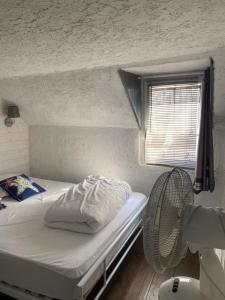a small room with a bed and a window at Maison de pêcheurs les petits quinquins in Étaples