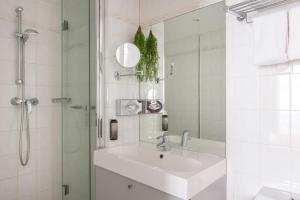 ein weißes Badezimmer mit Waschbecken und Dusche in der Unterkunft Hotel George - Astotel in Paris + 63 Fotos