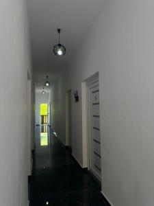 a hallway with a white wall and a door at Trojet e Mija in Theth