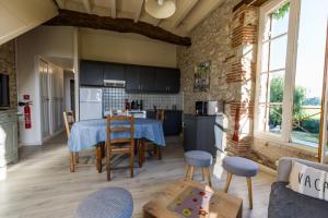 a kitchen with a table and chairs in a room at La tour du manoir in Arouille