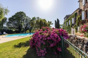 a bush of purple flowers on a fence near a pool at La tour du manoir in Arouille