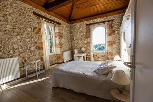 a bedroom with a bed and a stone wall at La tour du manoir in Arouille +38 photos