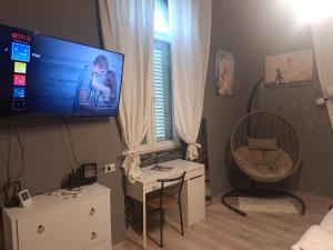 a living room with a flat screen tv and a chair at Peron 4-City & Station Stay in Rijeka