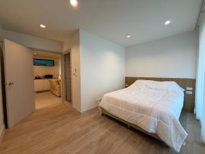 a bedroom with a large white bed and a hallway at 2 Bed & 2 Bath Suite, 4th floor in Ban Bang Toei (1)