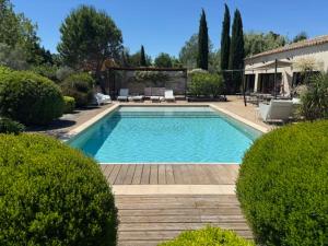 a large swimming pool in a yard with bushes at Mas de Bubu in Châteaurenard