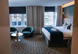 a hotel room with a bed and a chair at The George Hotel in Penrith