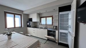 a kitchen with white cabinets and a table in it at Casa Marika in Valdisotto +11 photos