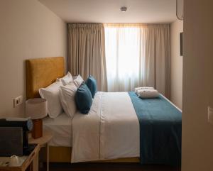 a bedroom with a large bed with a window at A Casita Clara in Amarante