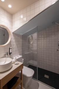 a bathroom with a toilet and a sink and a shower at A Casita Clara in Amarante