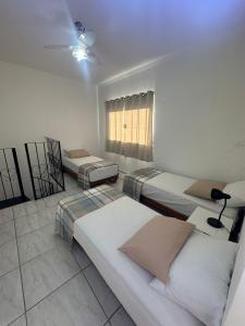 a room with three beds and a window at Apartamento Tio Du in Sorocaba