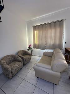 a living room with a couch and a chair at Apartamento Tio Du in Sorocaba