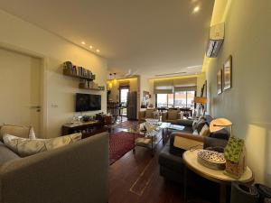 a living room with couches and a table at Batroun Escape, 2BR, 24-7 elect, beach view! in Batroûn