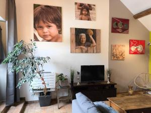 a living room with portraits of a child on the wall at La Closerie DAUVILLIERS in Roinville