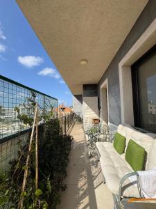 a balcony with a couch and chairs on a building at Batroun Escape, 2BR, 24-7 elect, beach view! in Batroûn