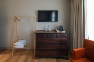 a bedroom with a dresser with a television on top at A Casita Clara in Amarante