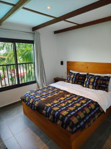 a bedroom with a bed and a large window at VILLA Fleurie in Mafia +19 photos