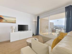a living room with a white couch and a tv at Apartamento de lujo vista mar en Torrox Costa in Torrox Costa