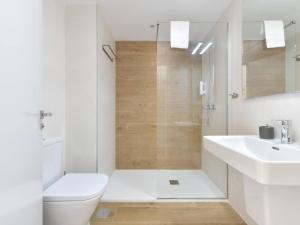 a white bathroom with a toilet and a sink at Apartamento de lujo vista mar en Torrox Costa in Torrox Costa