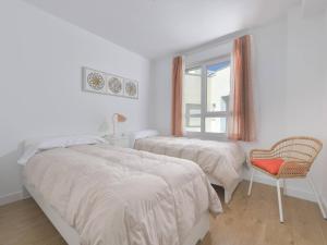 a bedroom with two beds and a chair and a window at Apartamento de lujo vista mar en Torrox Costa in Torrox Costa +20 photos