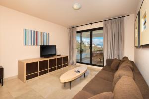 a living room with a couch and a tv at Spacious 3 bedrooms apartment side sea view in Torrox Costa