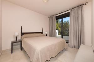 a white bedroom with a bed and a window at Spacious 3 bedrooms apartment side sea view in Torrox Costa +9 photos