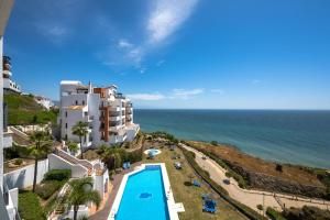 a view of a resort with a swimming pool and the ocean at Spacious 3 bedrooms apartment side sea view in Torrox Costa