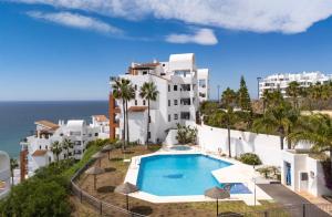 an aerial view of a building with a swimming pool and the ocean at Spacious 3 bedrooms apartment side sea view in Torrox Costa