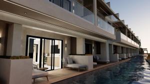 a hotel with a pool and chairs and a building at Nerion Hotel & Spa in Agia Marina Nea Kydonias
