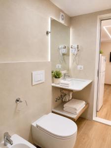 a bathroom with a toilet and a sink and a mirror at Flors Apartments in Durrës +79 photos