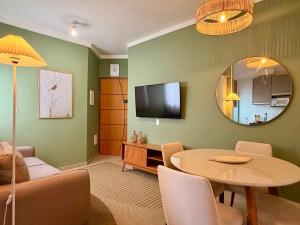 a living room with a table and a mirror at Apartamento Unicco 25, next to USP in São Carlos +3 photos