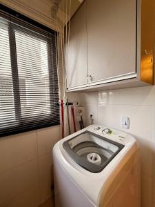 a washer and dryer in a small bathroom at Apartamento Unicco 25, next to USP in São Carlos