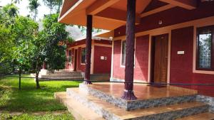 a house with wooden steps leading to a porch at Misty Slope in Ambalavayal