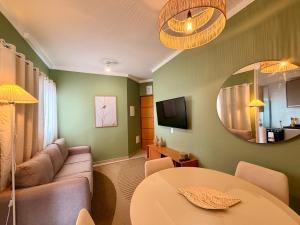 a living room with a couch and a table and a mirror at Apartamento Unicco 25, next to USP in São Carlos