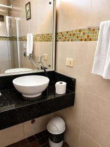 a bathroom with a sink and a mirror at Hotel Pousada Casuarinas in Recife