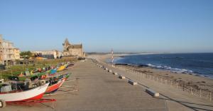 a row of boats are lined up on the beach at Villa Casa do Canal in Apúlia