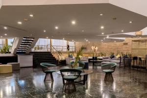 a lobby with chairs and tables in a building at Regente Palace Hotel in Buenos Aires