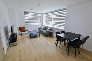 a living room with a couch and a table at Chertsey Modern 2-Bed Flat with Parking in Chertsey