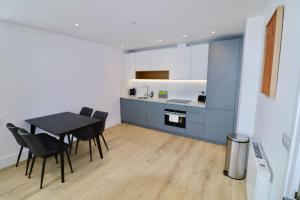 a kitchen and dining room with a table and chairs at Chertsey Modern 2-Bed Flat with Parking in Chertsey